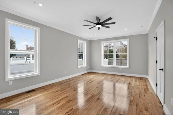 a view of a big room with wooden floor closet and windows