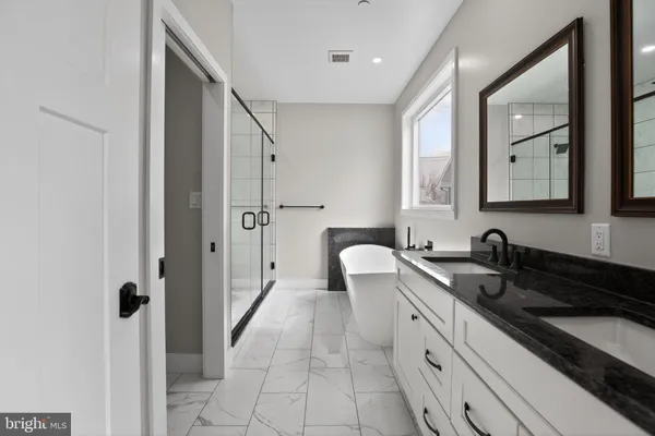 a spacious bathroom with a granite countertop sink and a mirror