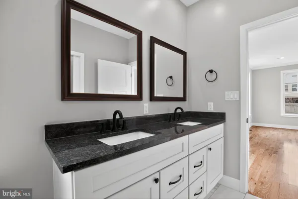 a bathroom with a granite countertop sink and a mirror