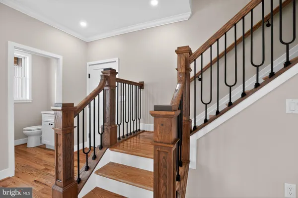 a view of staircase with lots of frames on wall and a window