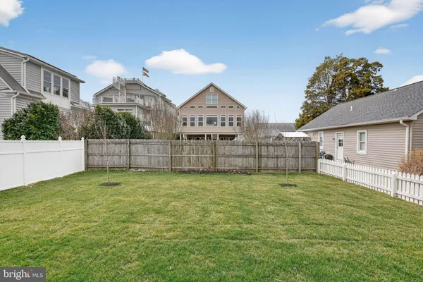 a view of a house with a yard and a large tree