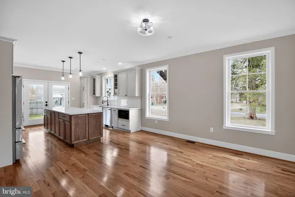 a large kitchen with kitchen island white cabinets and wooden floor