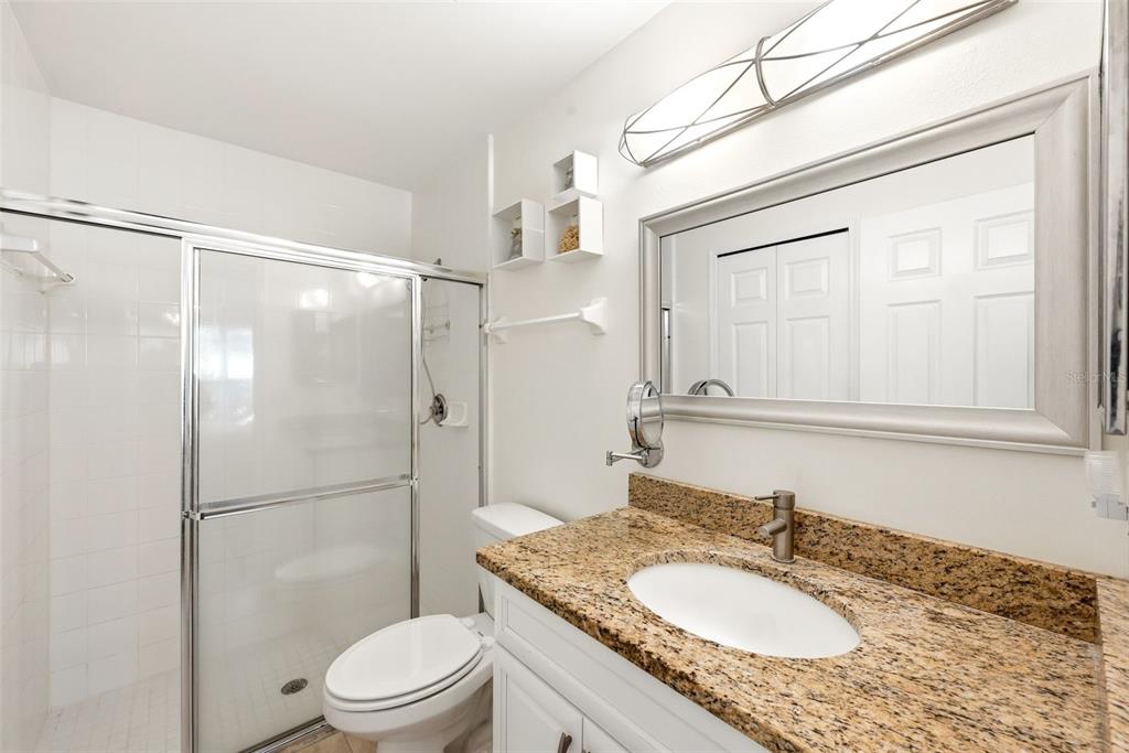 10618 Lake Ralph Drive Clermont, FL 34711 - Photo 13 of 26 a bathroom with a granite countertop sink toilet mirror vanity and shower