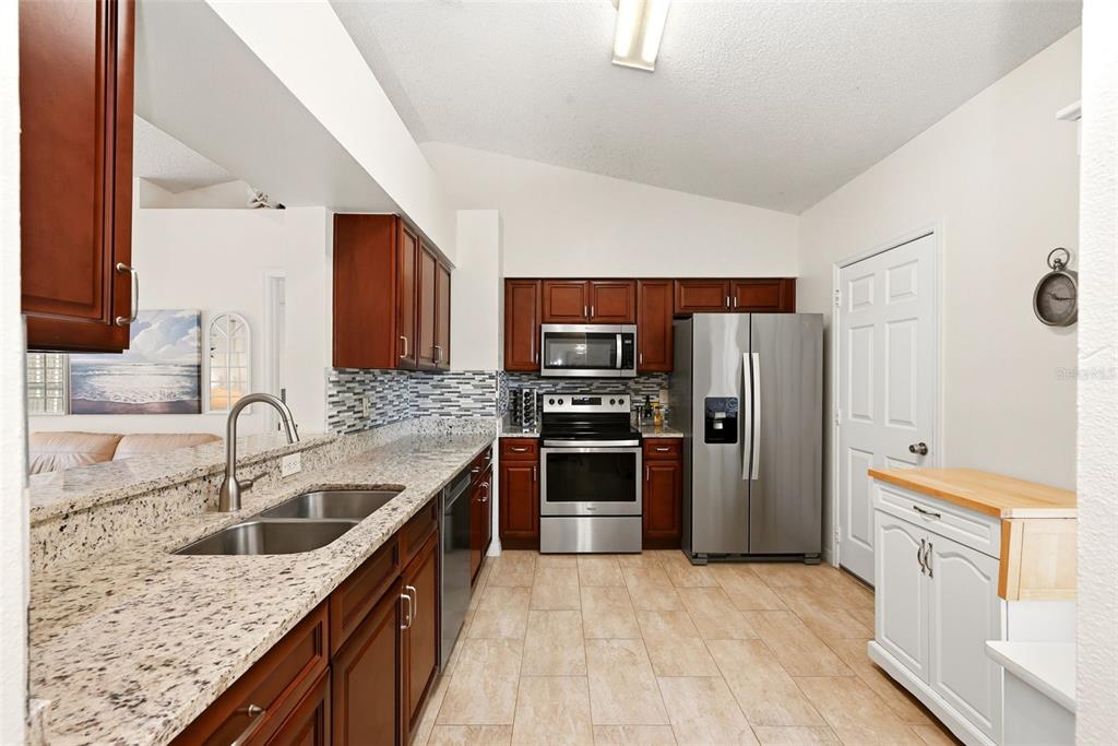 10618 Lake Ralph Drive Clermont, FL 34711 - Photo 9 of 26 a kitchen with stainless steel appliances granite countertop a sink stove and refrigerator