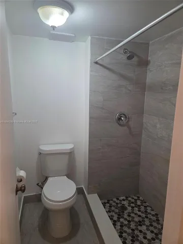 a bathroom with a toilet and a shower