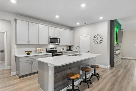 a large white kitchen with a table and chairs