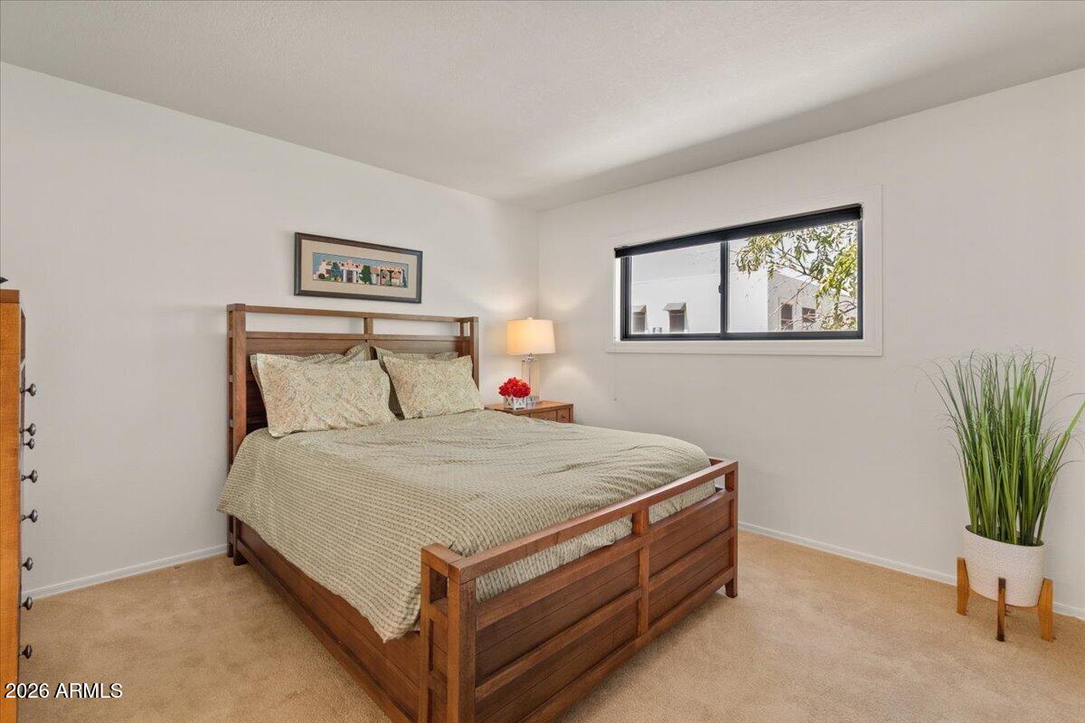 5525 East Thomas Road, Unit O12 Phoenix, AZ 85018 - Photo 8 of 27 a bed room with a bed and paintings on the wall