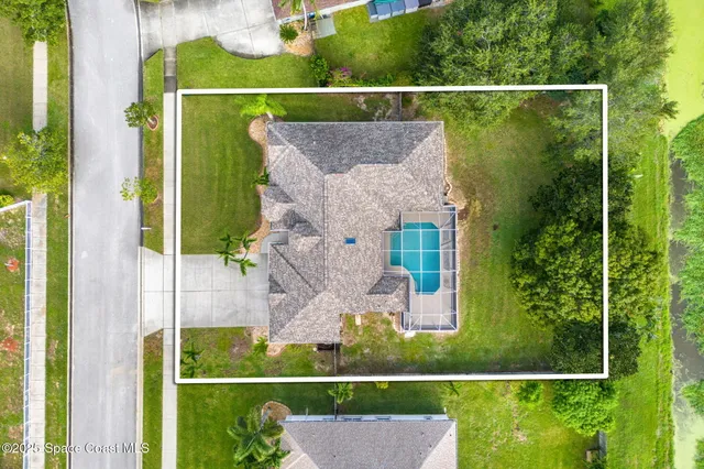 an aerial view of residential houses with outdoor space and trees