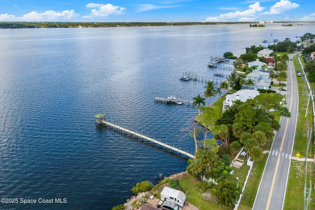 an aerial view of residential houses with outdoor space and river