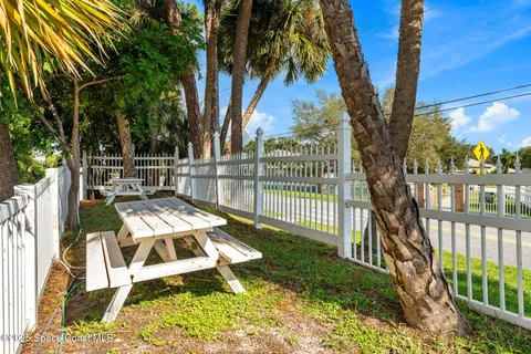 a view of a house with a yard and palm trees