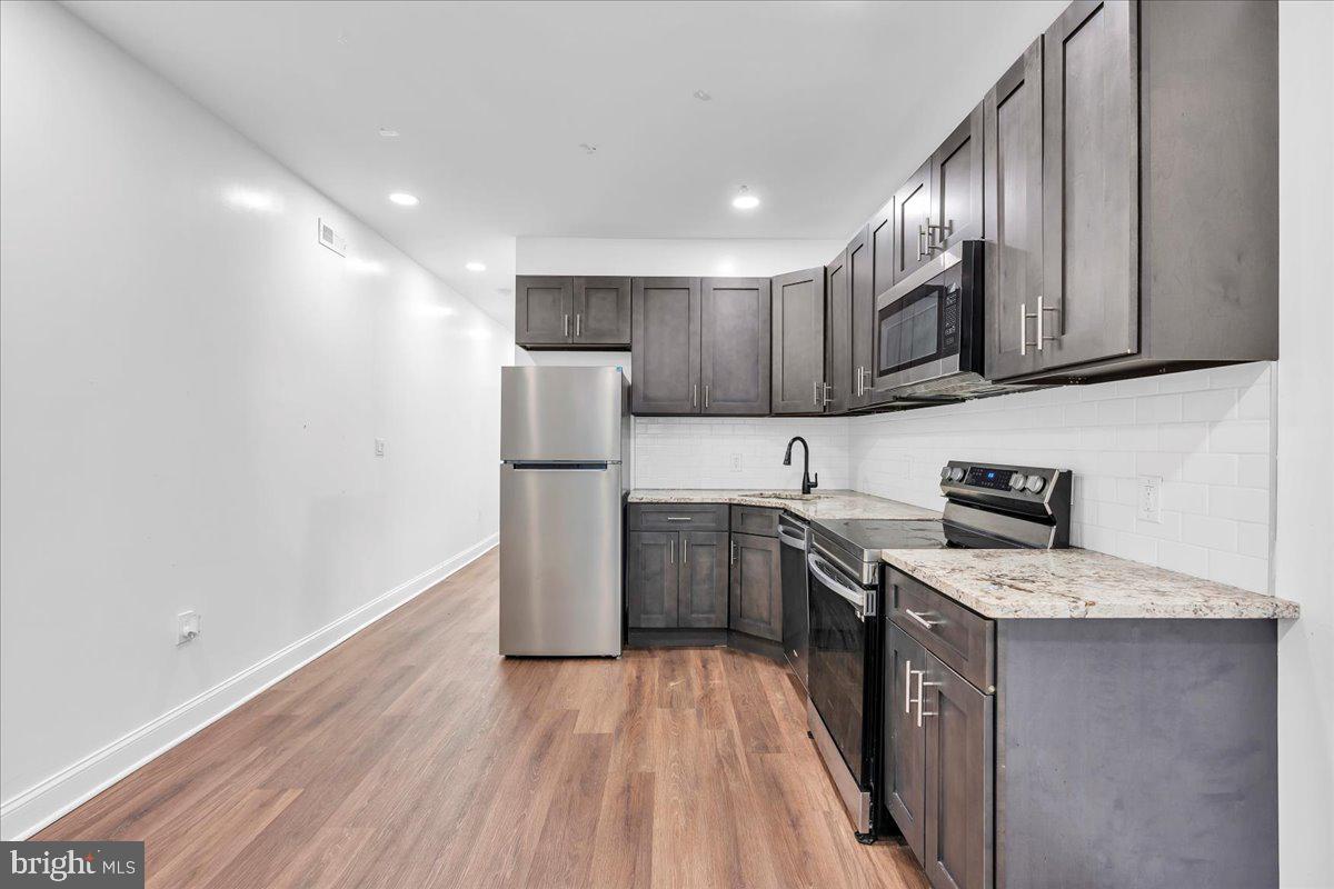 1917 West Venango Street Philadelphia, PA 19140 - Photo 5 of 24 a kitchen with a sink a microwave a refrigerator and cabinets