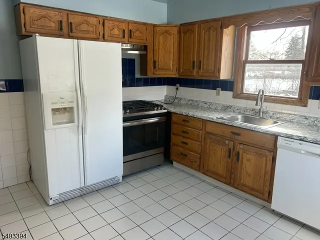 a kitchen with stainless steel appliances granite countertop a refrigerator sink and cabinets