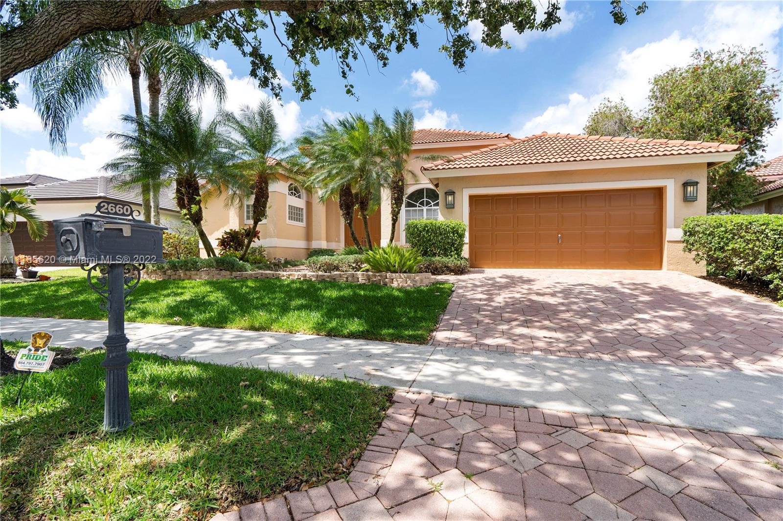 2660 Palmer Place Weston, FL 33332 - Photo 1 of 22 a front view of a house with a garden and palm trees