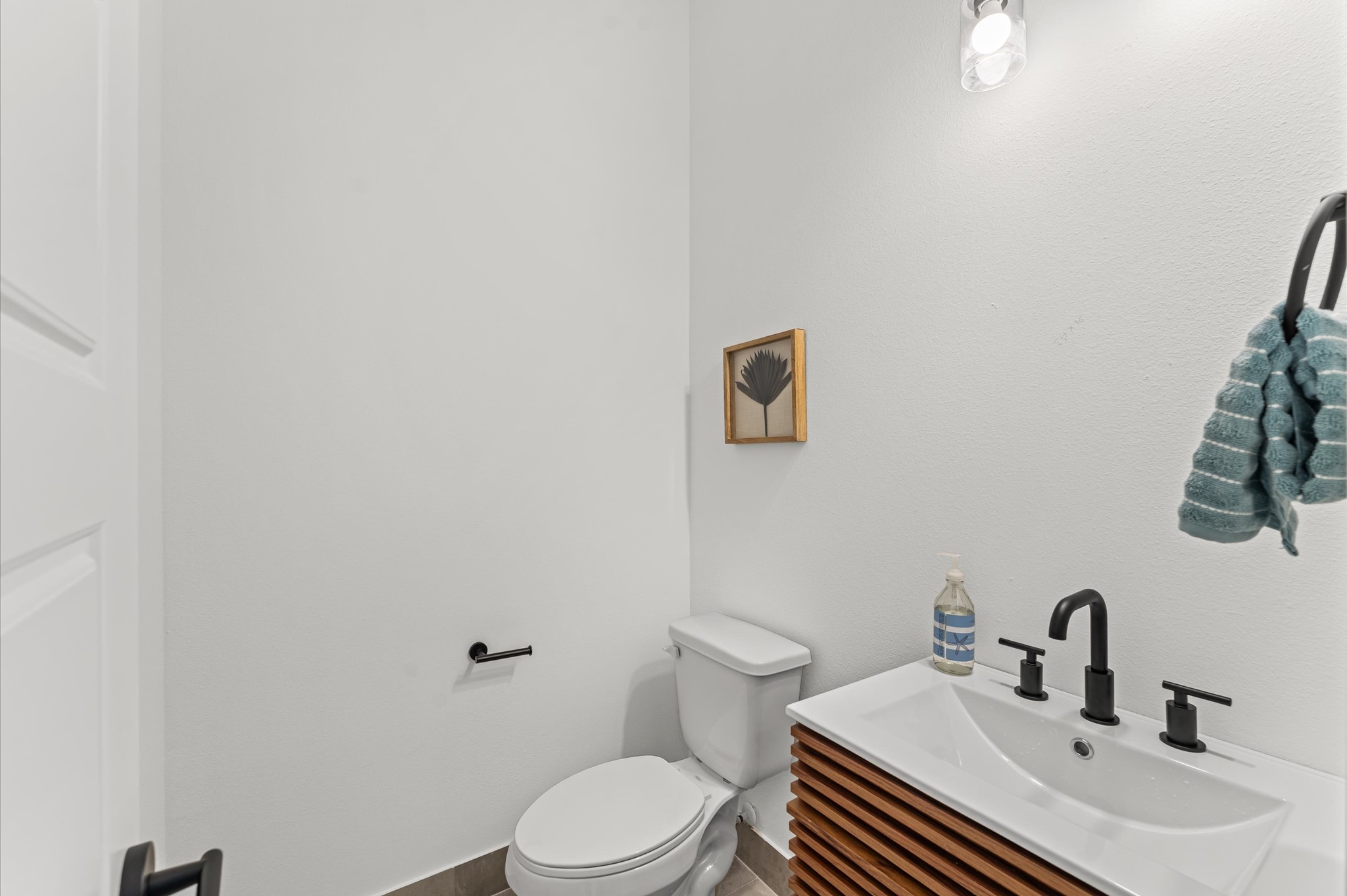 3002 Jensen Drive Houston, TX 77026 - Photo 20 of 42 Tucked conveniently near the living area, this powder room blends accessibility with sleek contemporary style. Clean lines and modern fixtures define the space, from the minimalist vanity to the streamlined sink and faucet.