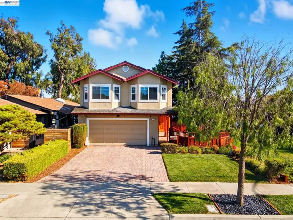 a front view of a house with a yard and trees