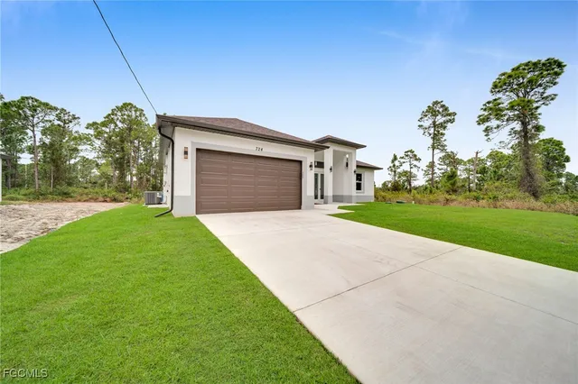 a front view of a house with a yard and garage