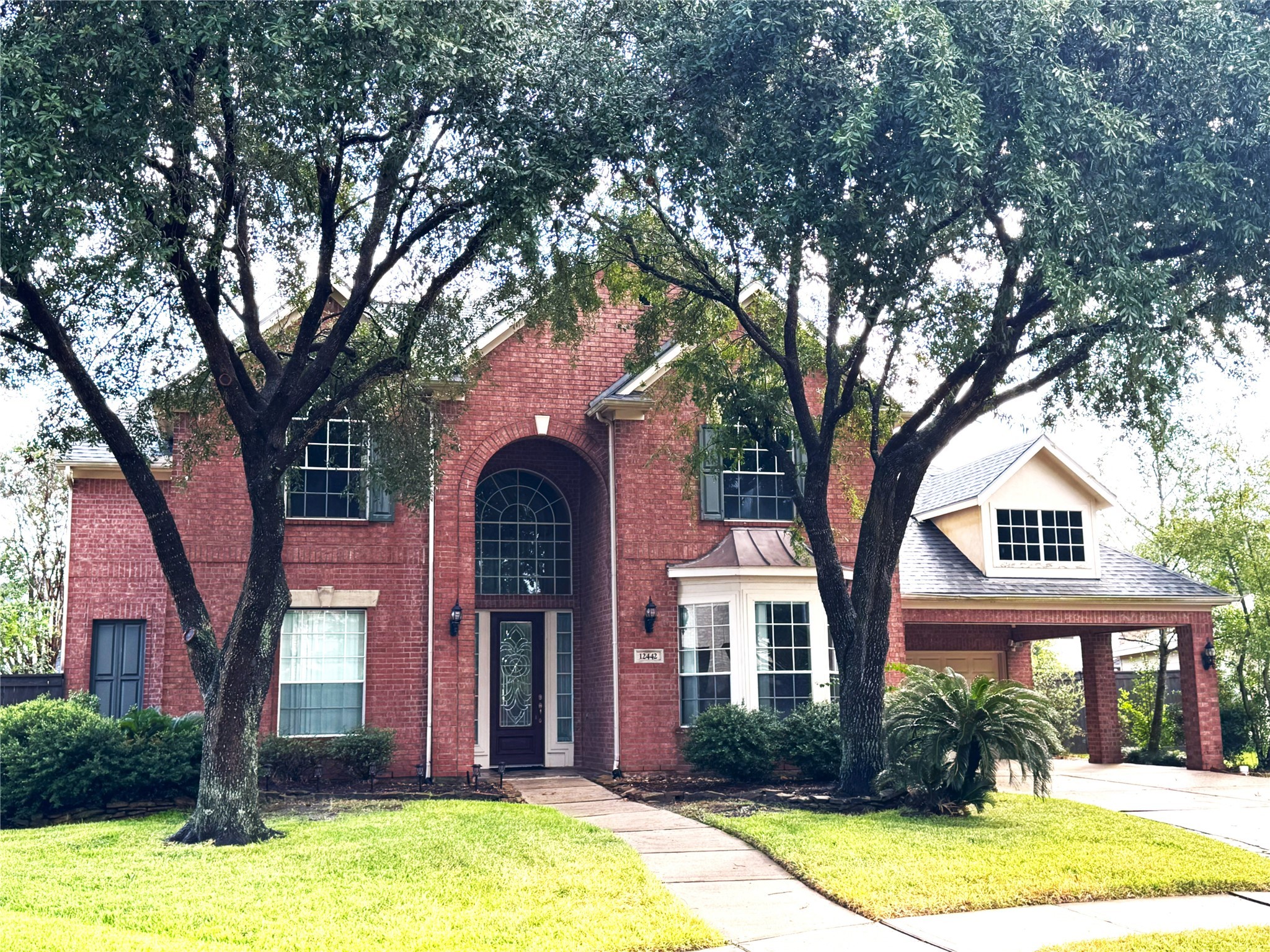 a front view of house with yard and trees around