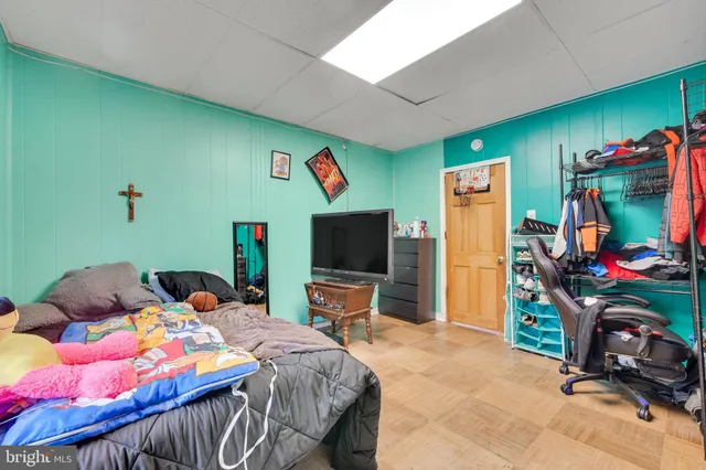 a bedroom with a bed and a flat tv screen on the dresser