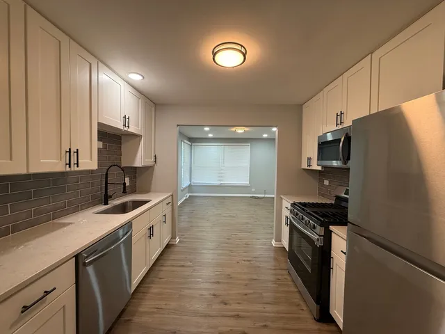 a kitchen with stainless steel appliances a sink stove and refrigerator