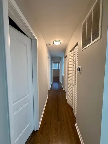 a view of a hallway with wooden floor and staircase
