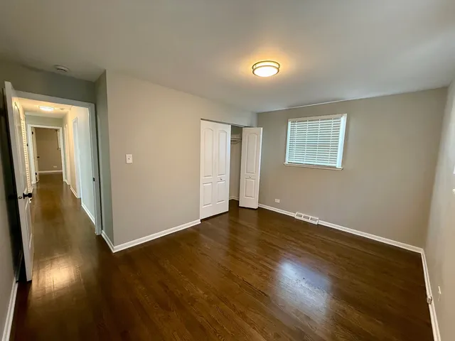 an empty room with wooden floor and a window