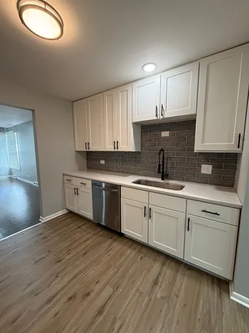 a kitchen with granite countertop a sink cabinets stainless steel appliances and a window