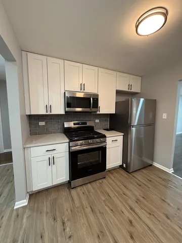 a kitchen with granite countertop a refrigerator stove and microwave