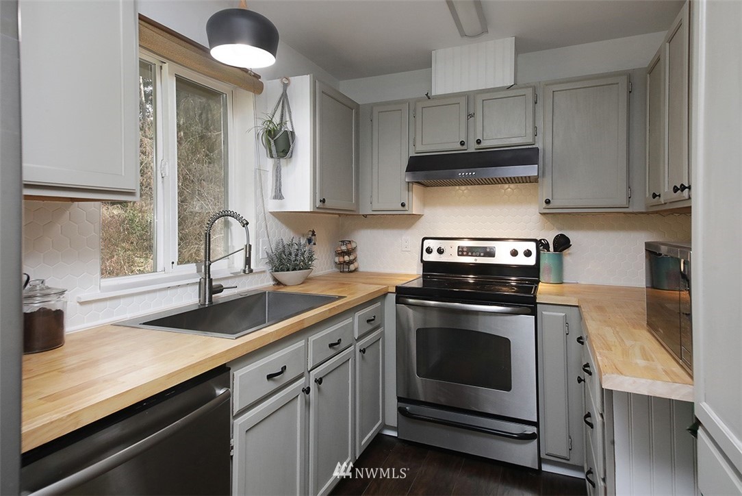 3336 East Harbor Road Langley, WA 98260 - Photo 10 of 29 a kitchen with stainless steel appliances granite countertop a sink stove and cabinets