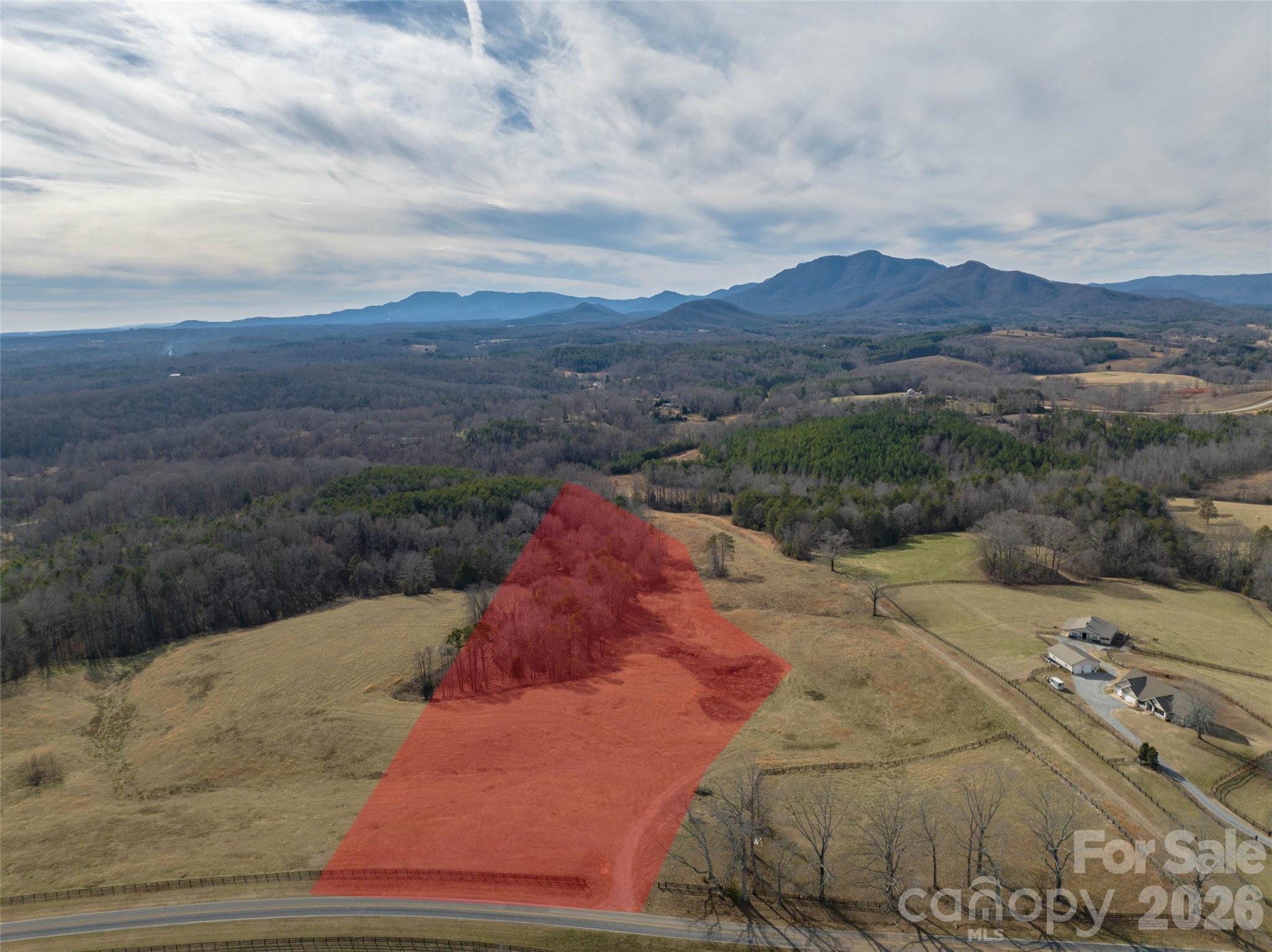 a view of a dry yard with mountains in the background