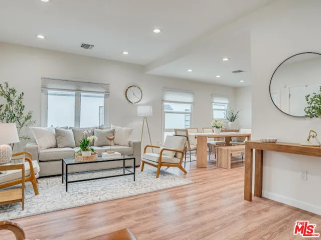 a living room with furniture a dining table and wooden floor