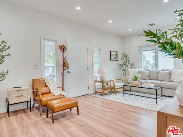 a living room with furniture a table and wooden floor