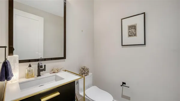 a bathroom with a toilet sink vanity and mirror