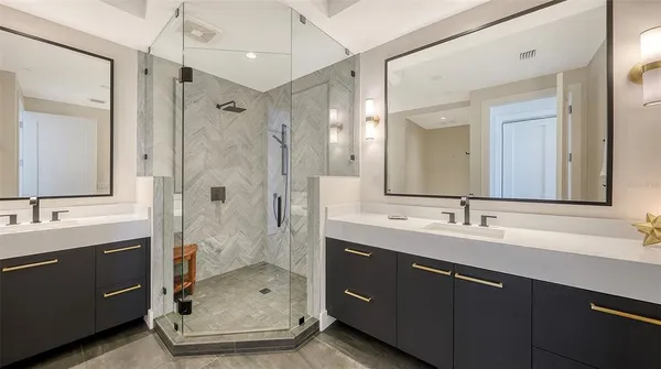 a bathroom with a double vanity sink mirror double shower and a bathtub