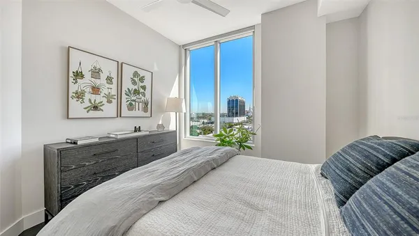 a spacious bedroom with a bed and a painting on the wall