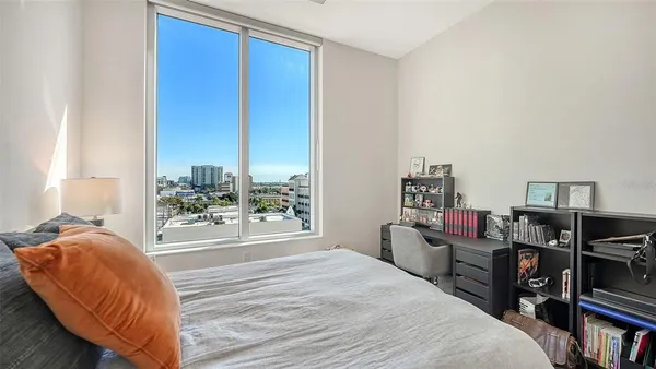 a bedroom with a bed furniture and a flat tv screen