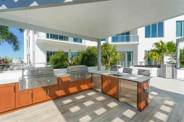 a view of living room kitchen with stainless steel appliances granite countertop a stove and a large window