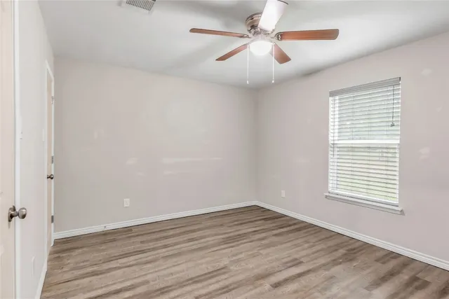 wooden floor in an empty room with a window