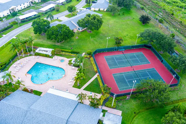 an aerial view of residential houses with outdoor space and lake view