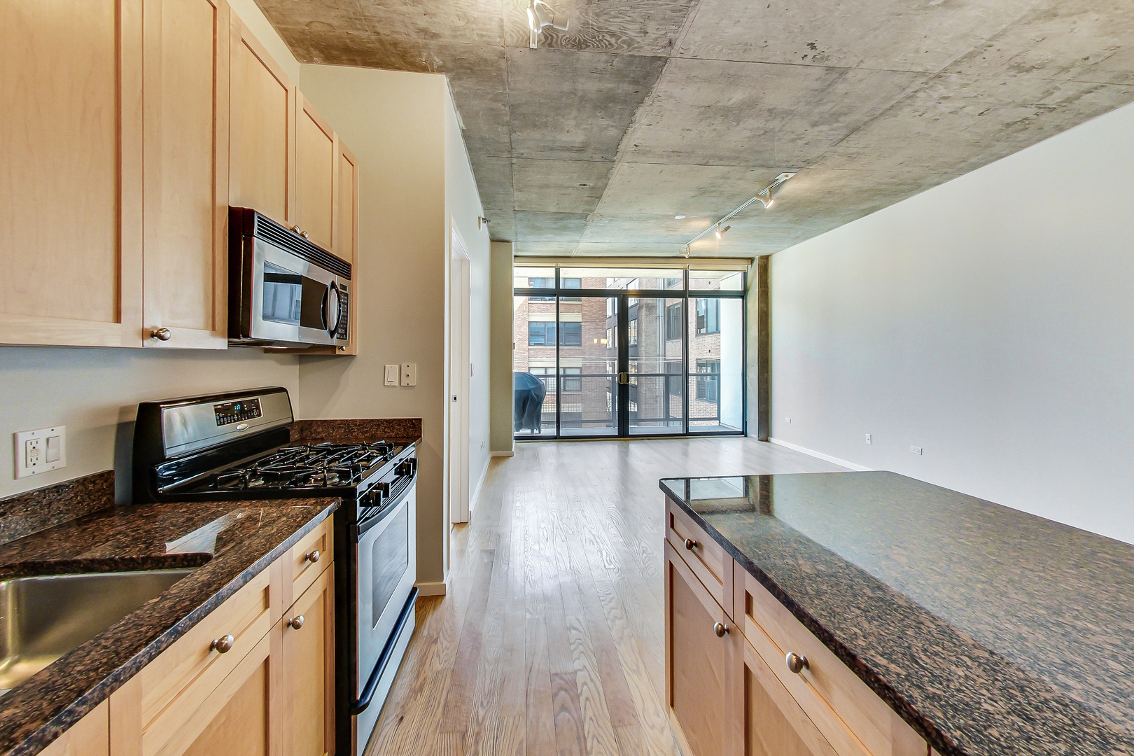 321 South Sangamon Street, Unit 408 Chicago, IL 60607 - Photo 16 of 31 a kitchen with granite countertop a stove a sink dishwasher and cabinets with wooden floor