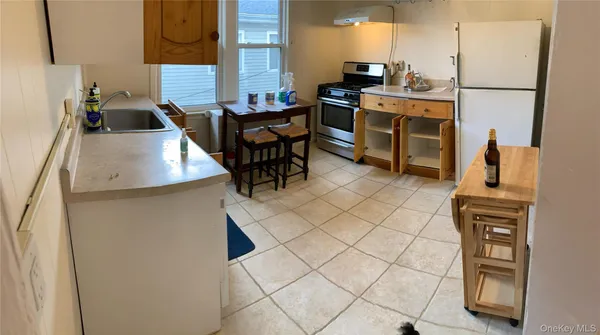 a kitchen with stainless steel appliances kitchen island granite countertop a refrigerator and a stove top oven