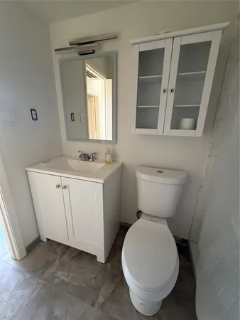 a bathroom with a toilet sink and mirror