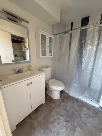 a bathroom with a sink toilet a mirror and shower