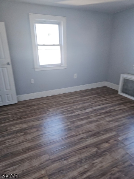 33 Glover Avenue Paterson, NJ 07501 - Photo 4 of 10 an empty room with wooden floor and windows