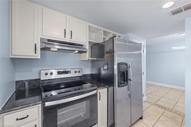 a kitchen with stainless steel appliances granite countertop a refrigerator and a stove