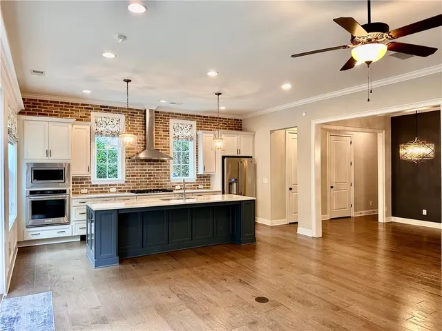 a view of kitchen with stainless steel appliances granite countertop a stove and a refrigerator