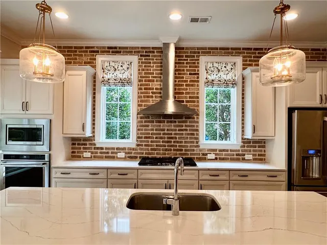 a kitchen with stainless steel appliances granite countertop a sink and a counter space