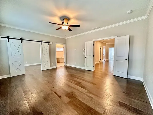 a view of a livingroom with wooden floor and a ceiling fan