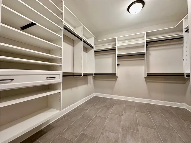 a view of walk in closet with empty racks