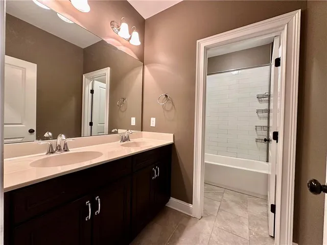 a bathroom with a bathtub a double vanity sink and mirror