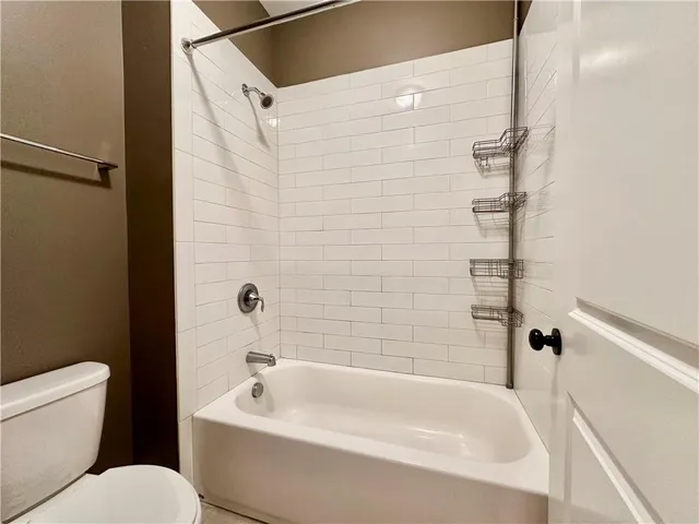 a white bath tub sitting next to a white toilet and a sink